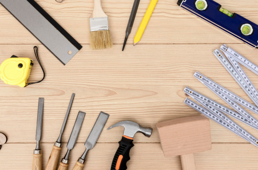 Affordable DIY home repairs with basic tools laid out on a wooden workbench for beginner projects.