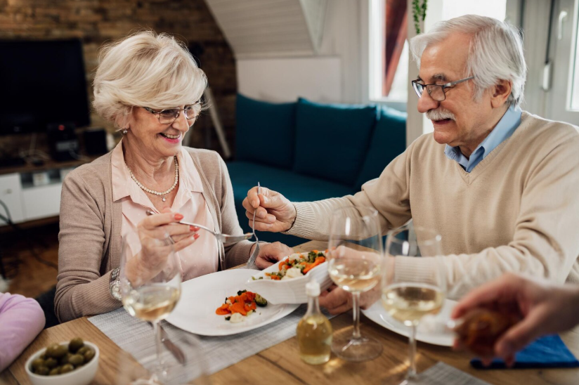 Best senior discounts for dining out with older couple enjoying a restaurant-style meal.