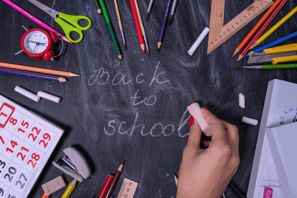 Back to school shopping tips with organized school supplies laid out around a chalkboard.